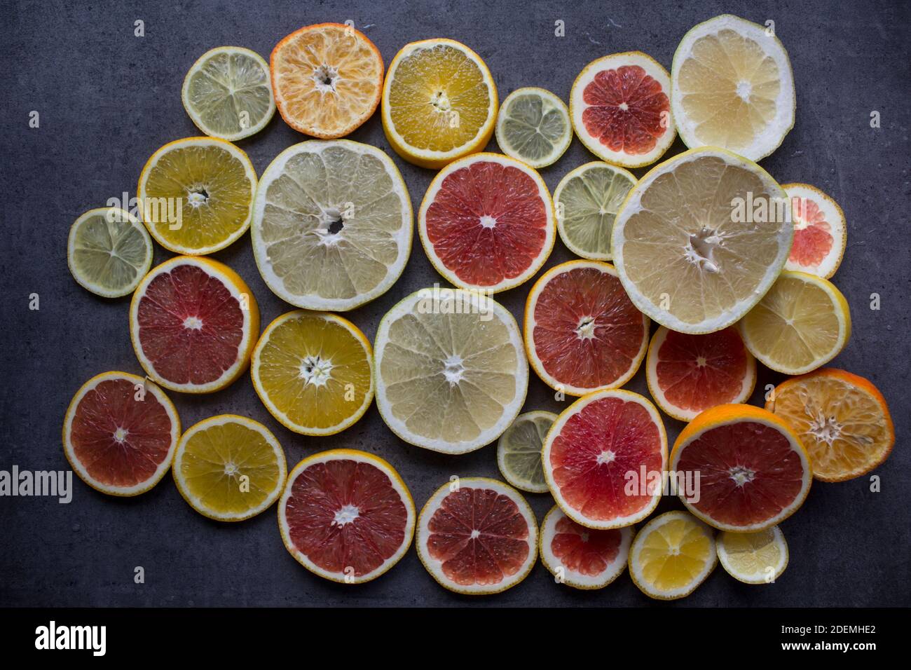 Red orange slices on a table. Fruit texture close up photo. Dark gray background with copy space. Stock Photo