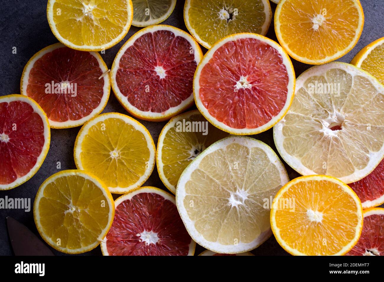 Red orange slices on a table. Fruit texture close up photo. Dark gray background with copy space. Stock Photo