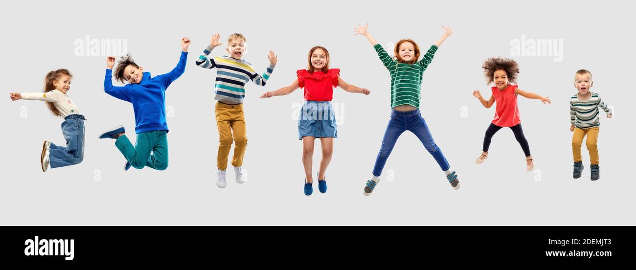 happy children jumping in air over grey background Stock Photo - Alamy