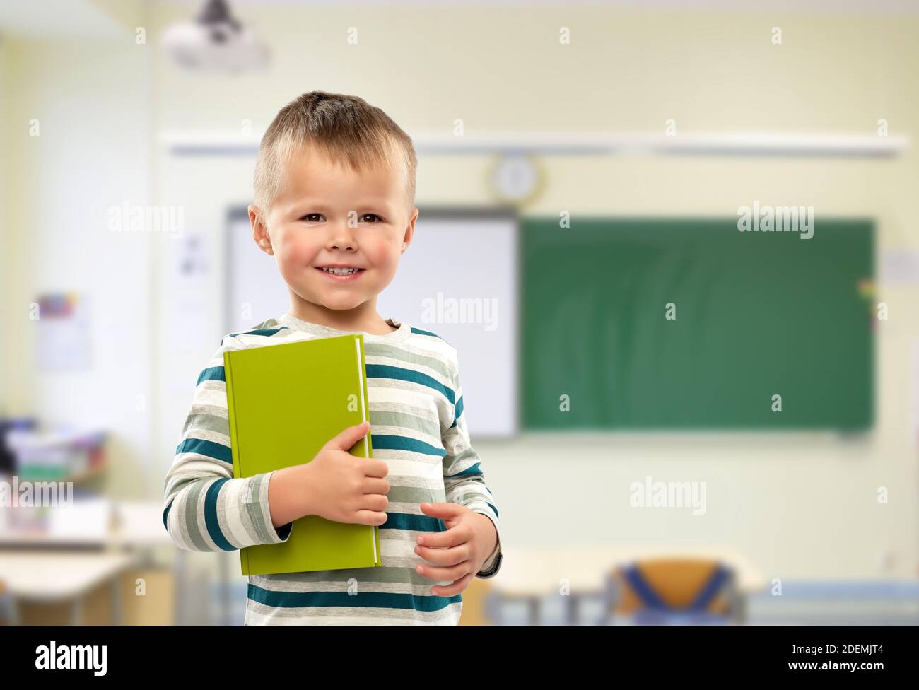 portrait of smiling boy holding book at school Stock Photo - Alamy