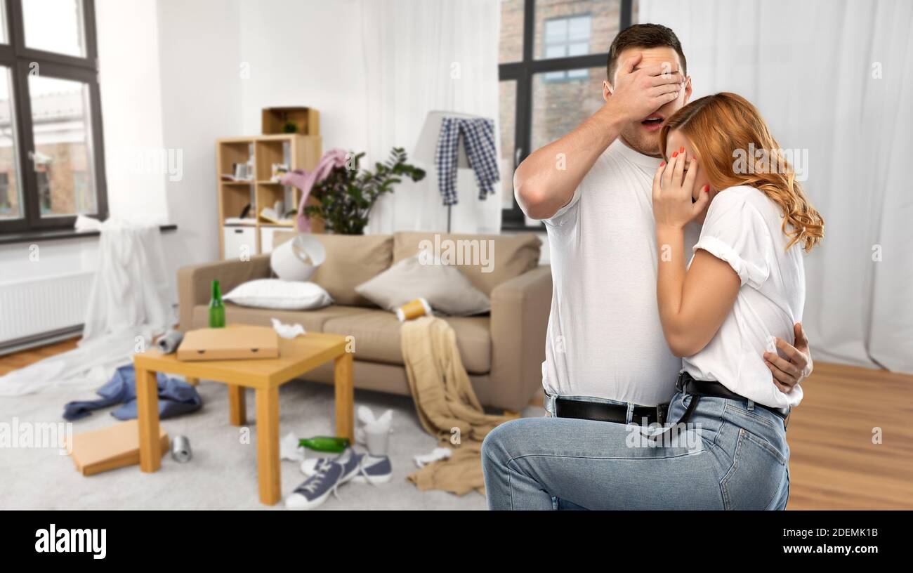 scared couple over messy home room Stock Photo