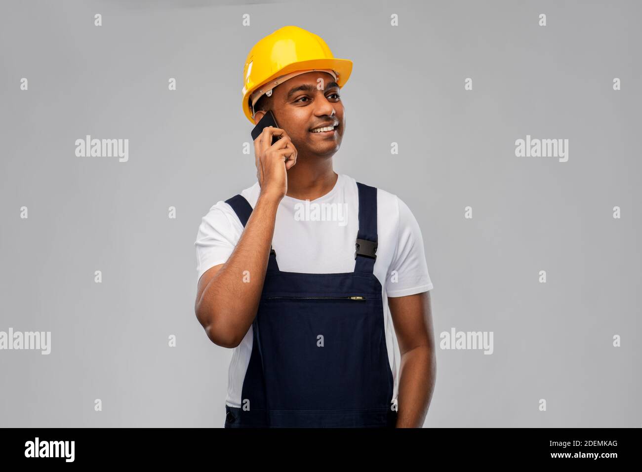 indian builder in helmet calling on smartphone Stock Photo