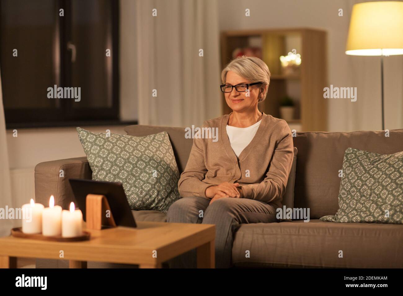 Mature woman watching tablet sofa hi-res stock photography and images ...