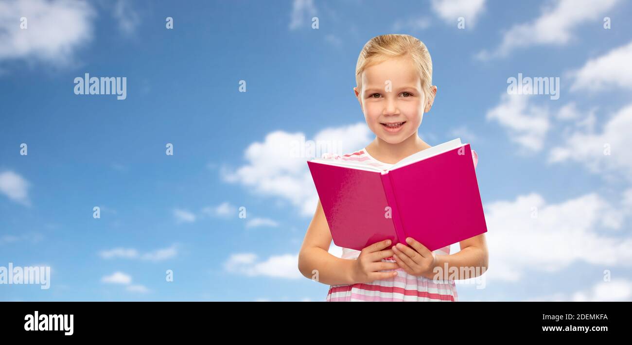 smiling little girl reading book Stock Photo - Alamy