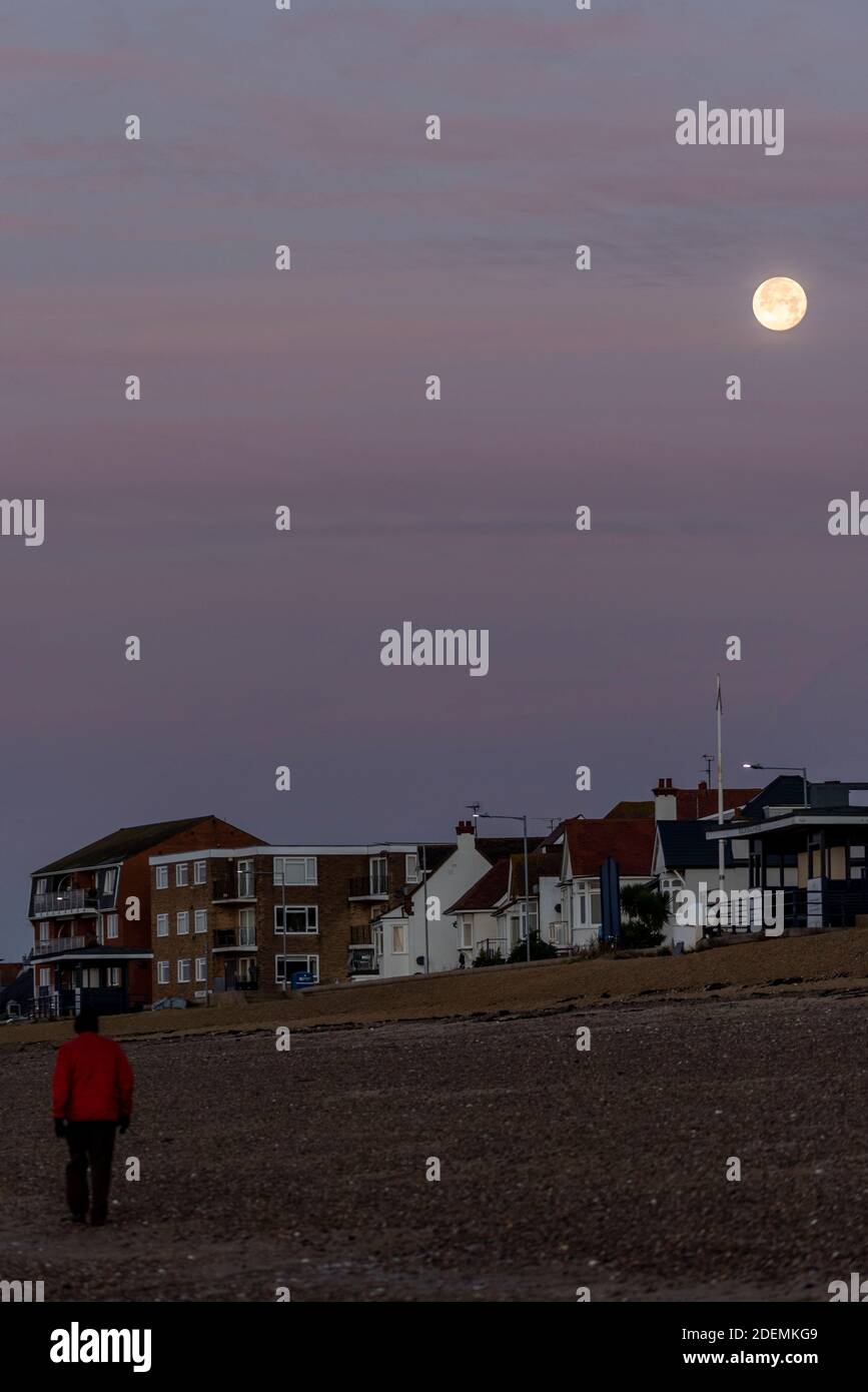 A male walks along the beach under a Full Beaver Moon at Southend on Sea, Essex, UK, on the first day of meteorological winter. COVID 19 lockdown walk Stock Photo