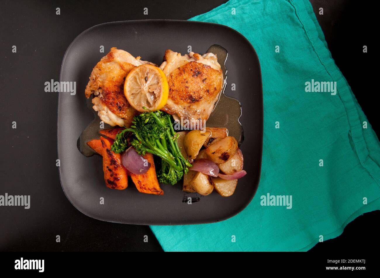 crispy chicken thighs with fingerling potatoes, carrots and green vegetables Stock Photo Alamy
