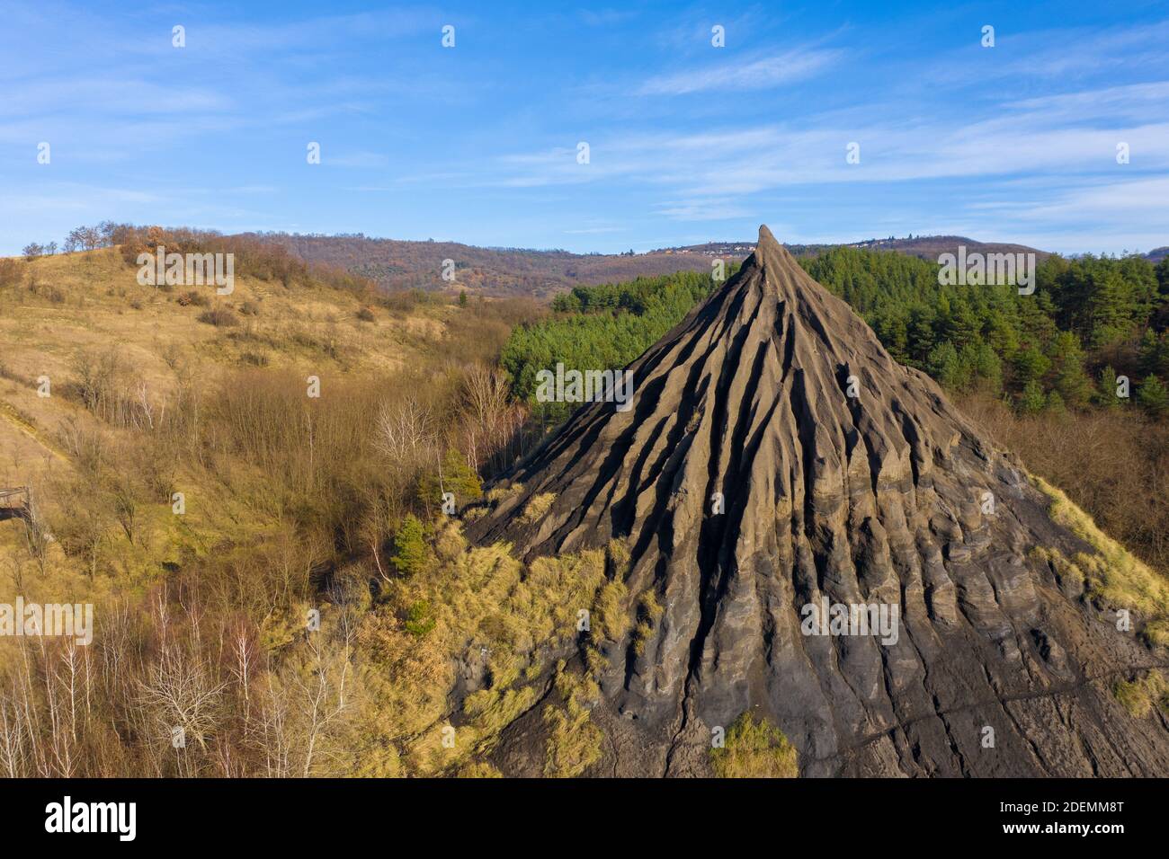 Salgótarján, Hungary - Aerial view of abandoned slag heap covered by grass against blue sky, autumn landscape Stock Photo