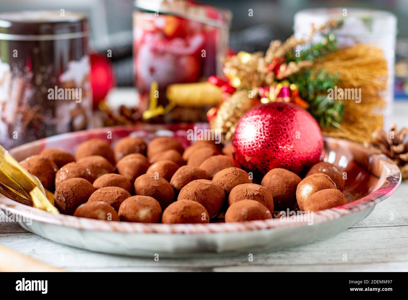 German Marzipan potatoes on a decorativ christmas plate with ornaments and cookie tins Stock Photo