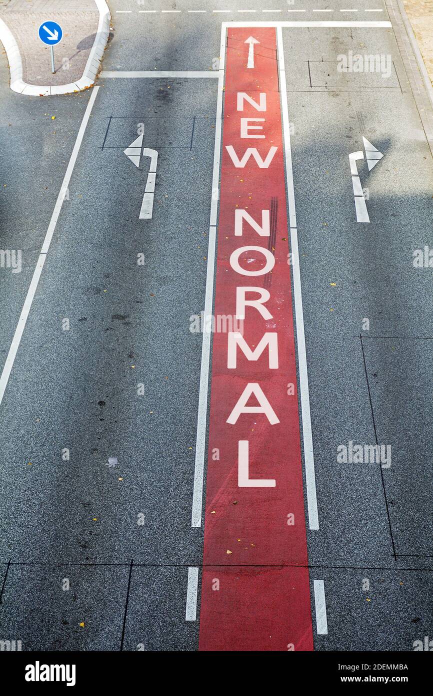 Asphalt road with marked lanes and directional arrows, text New Normal, coronavirus pandemic concept, selected focus Stock Photo