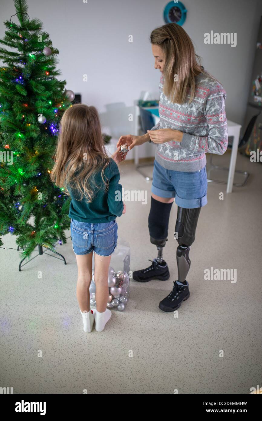 Disabled woman with her child decorated Christmas tree. Stock Photo