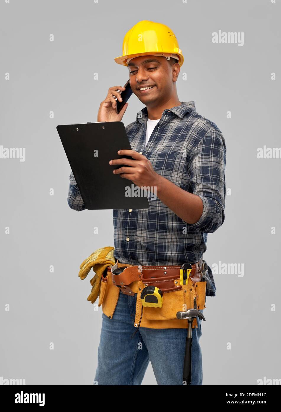indian builder in helmet calling on smartphone Stock Photo