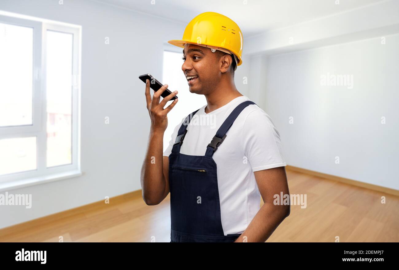 happy indian builder recording voice on smartphone Stock Photo