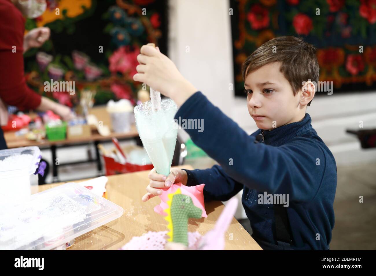 Child filling toy with styrofoam balls in workshop Stock Photo