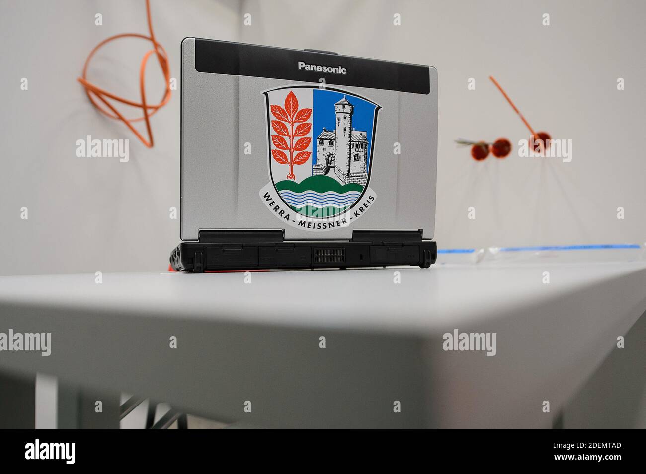 01 December 2020, Hessen, Eschwege: A laptop with the coat of arms of the Werra-Meissner district is standing in the gymnasium of the upper secondary school during the construction of a vaccination centre. In Eschwege in the Werra-Meissner district, a vaccination centre is being set up by the district and various disaster control organisations. Photo: Swen Pförtner/dpa Stock Photo