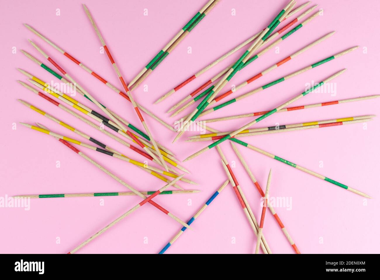 directly above view of jumble of wooden mikado pick-up sticks on pink background Stock Photo