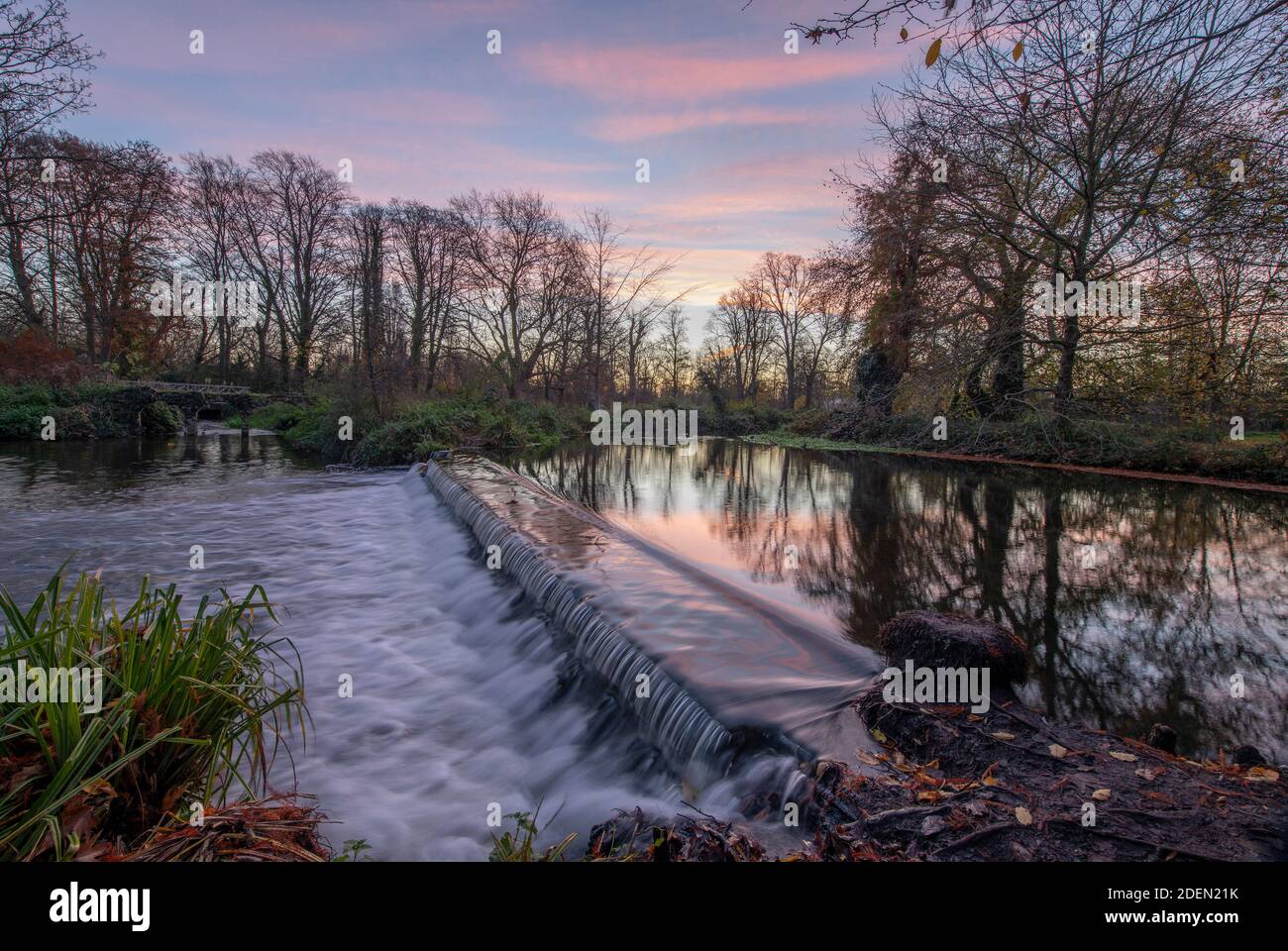 Morden Hall Park, London, UK. 1 December 2020. Dawn breaksover a river weir on the Wandle, a tributary of the river Thames, in south London. Stock Photo