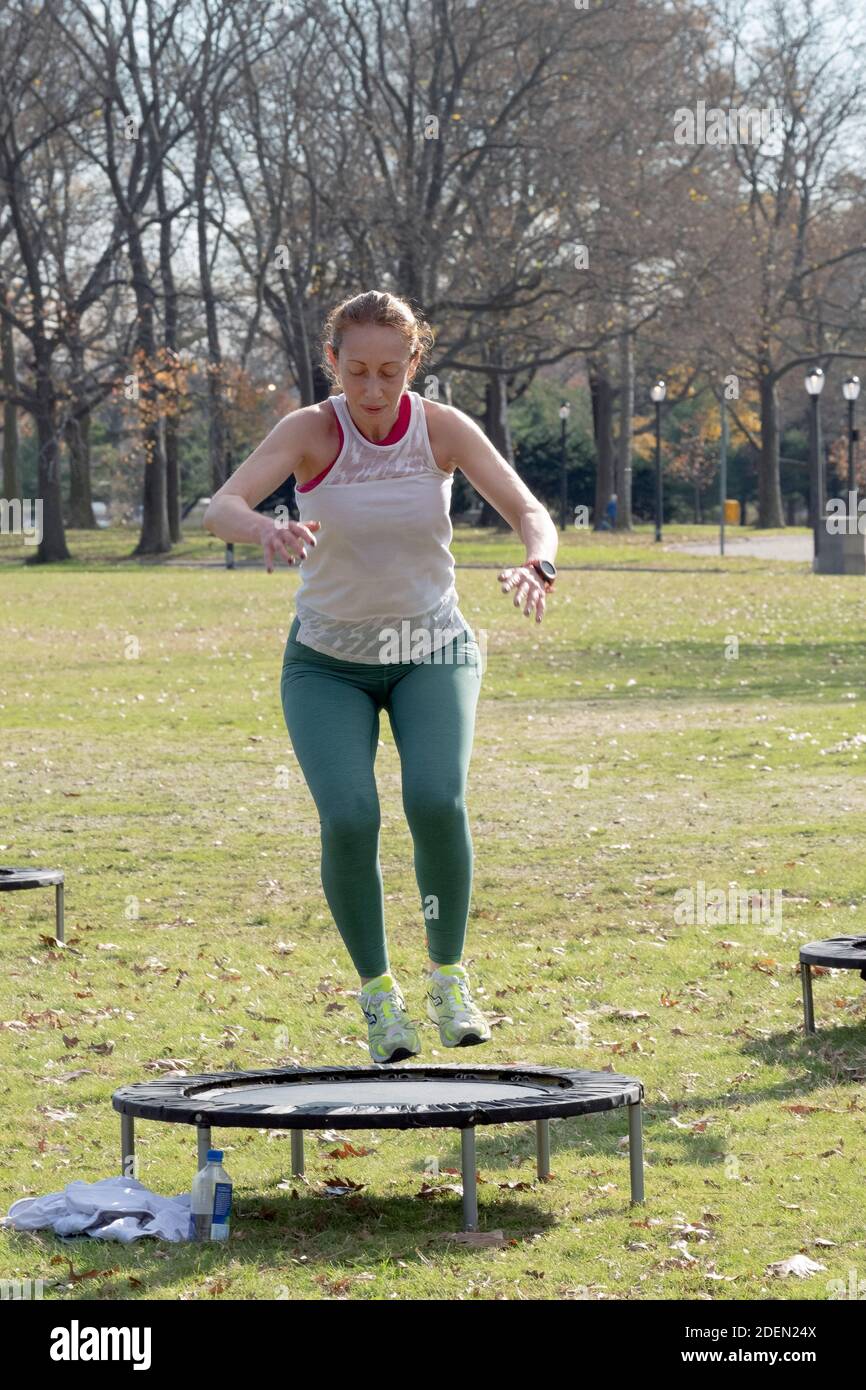 Women in an Urban Rebounding class dancing while on a small trampoline. In Flushing Meadows Corona Park in Queens, New York City. Stock Photo