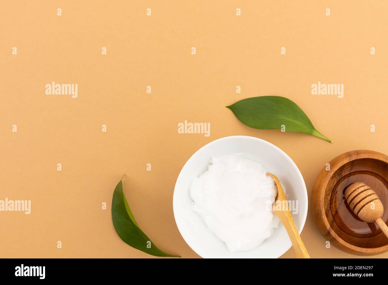 Bowls with yoghurt and dressing on yellow background Stock Photo