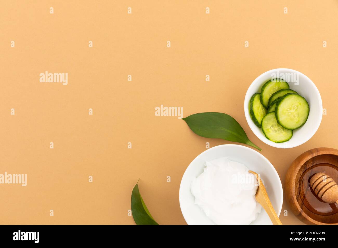 Bowls with yoghurt, cucumber and dressing on yellow background Stock Photo