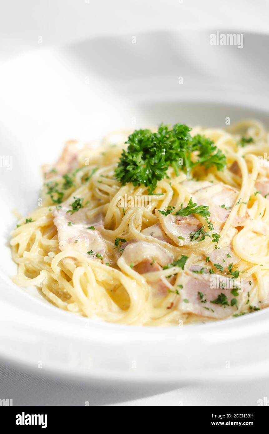 spaghetti carbonara italian pasta dish on white table background Stock Photo