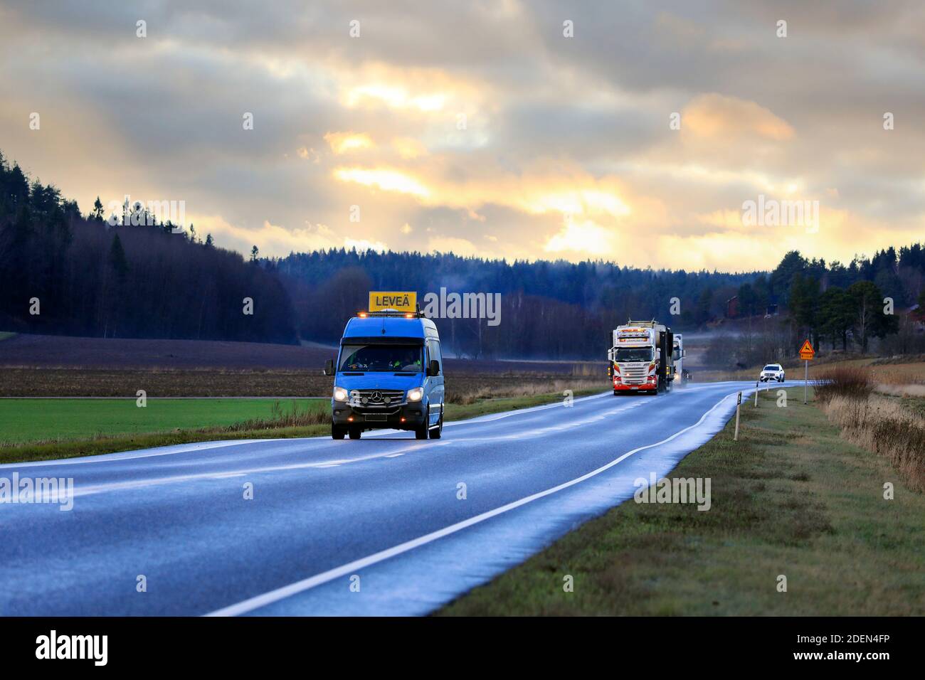 Pilot vehicle in front of Scania R730 truck of Janhunen which hauls Metso Nordberg jaw crusher as exceptional load. Salo, Finland. November 26, 2020. Stock Photo