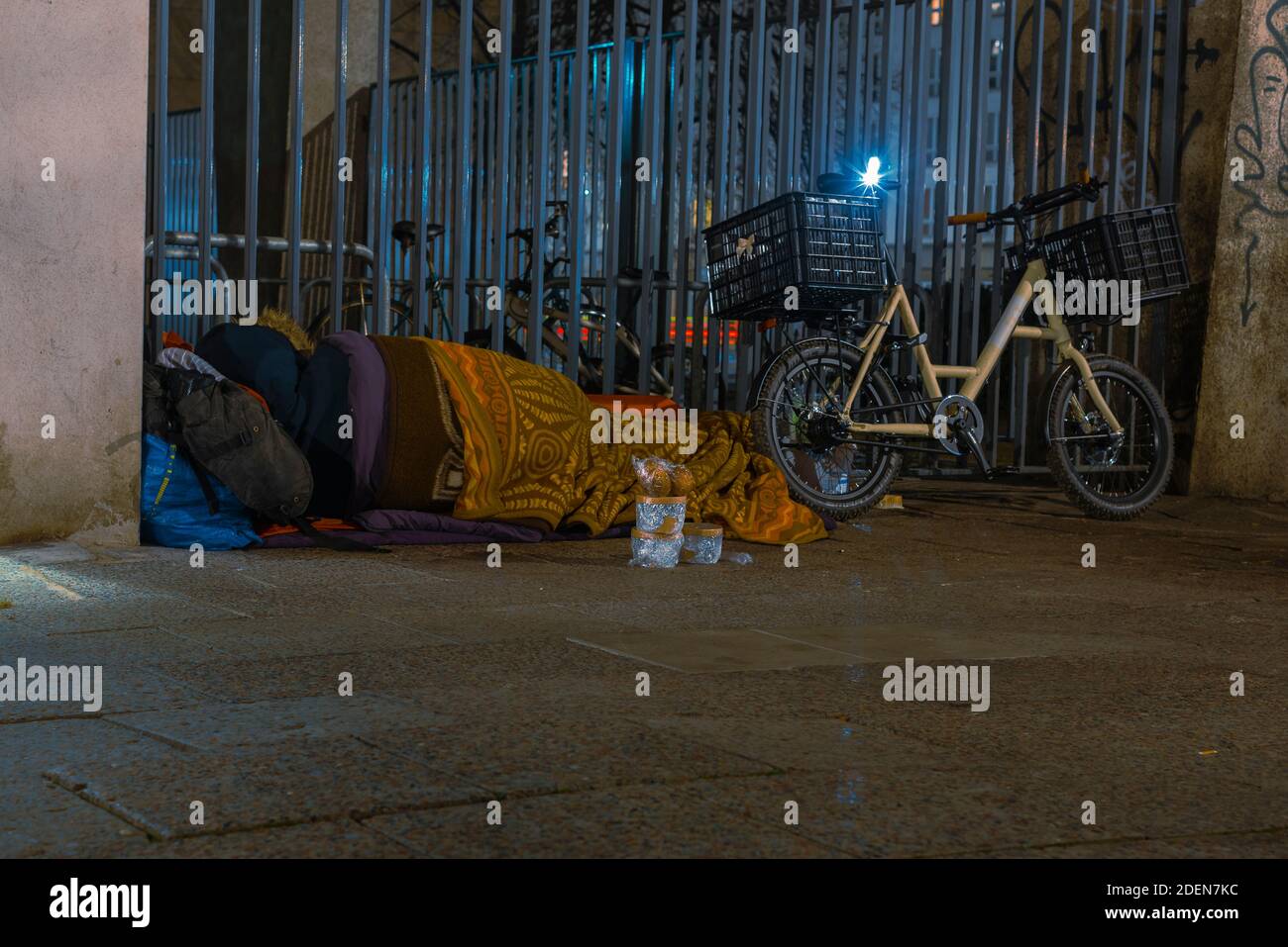 Homeless Man sleeping on sidewalk, Homeless man sleeping in winter, homeless man in sleeping bag on the street, sidewalk, Berlin unter den Linden Stock Photo