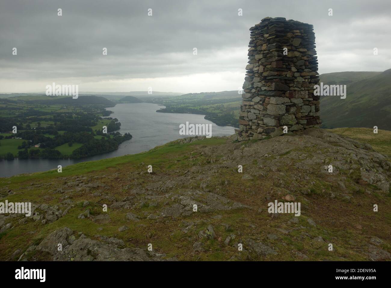 The Large Dry Stone Cairn & Ullswater Lake from the Wainwright ''Hallin Hill' in Martindale, Lake District National Park, Cumbria, England, UK. Stock Photo