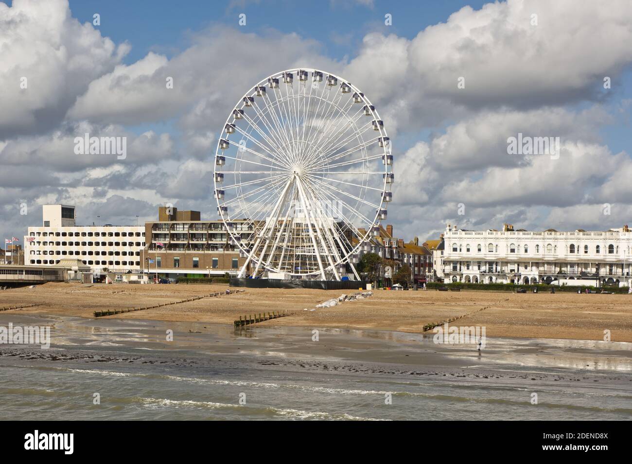Seafront and beach at Worthing, West Sussex, England. With Ferris wheel viewed from pier. Stock Photo