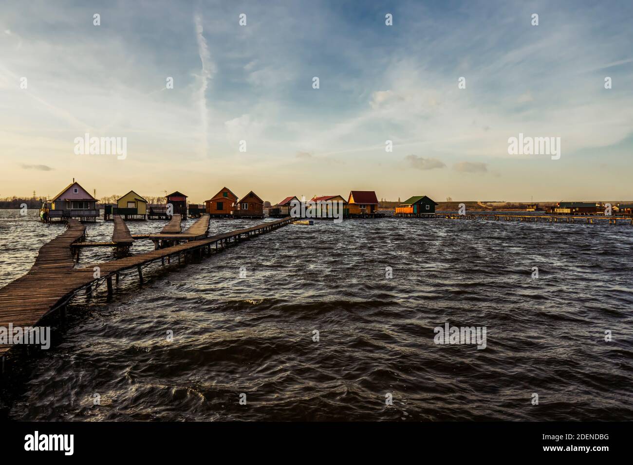 Village built over the lake Bokod captured in the early sunset. Wooden