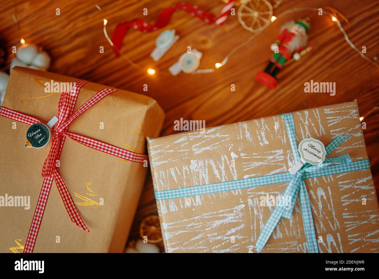 Wooden Table With New Year S Gifts And Christmas Decor Gift Boxes In Craft Wrapping Paper With Decorative Clothespin Garlands Ribbon And Peel Oranges In Background Stock Photo Alamy