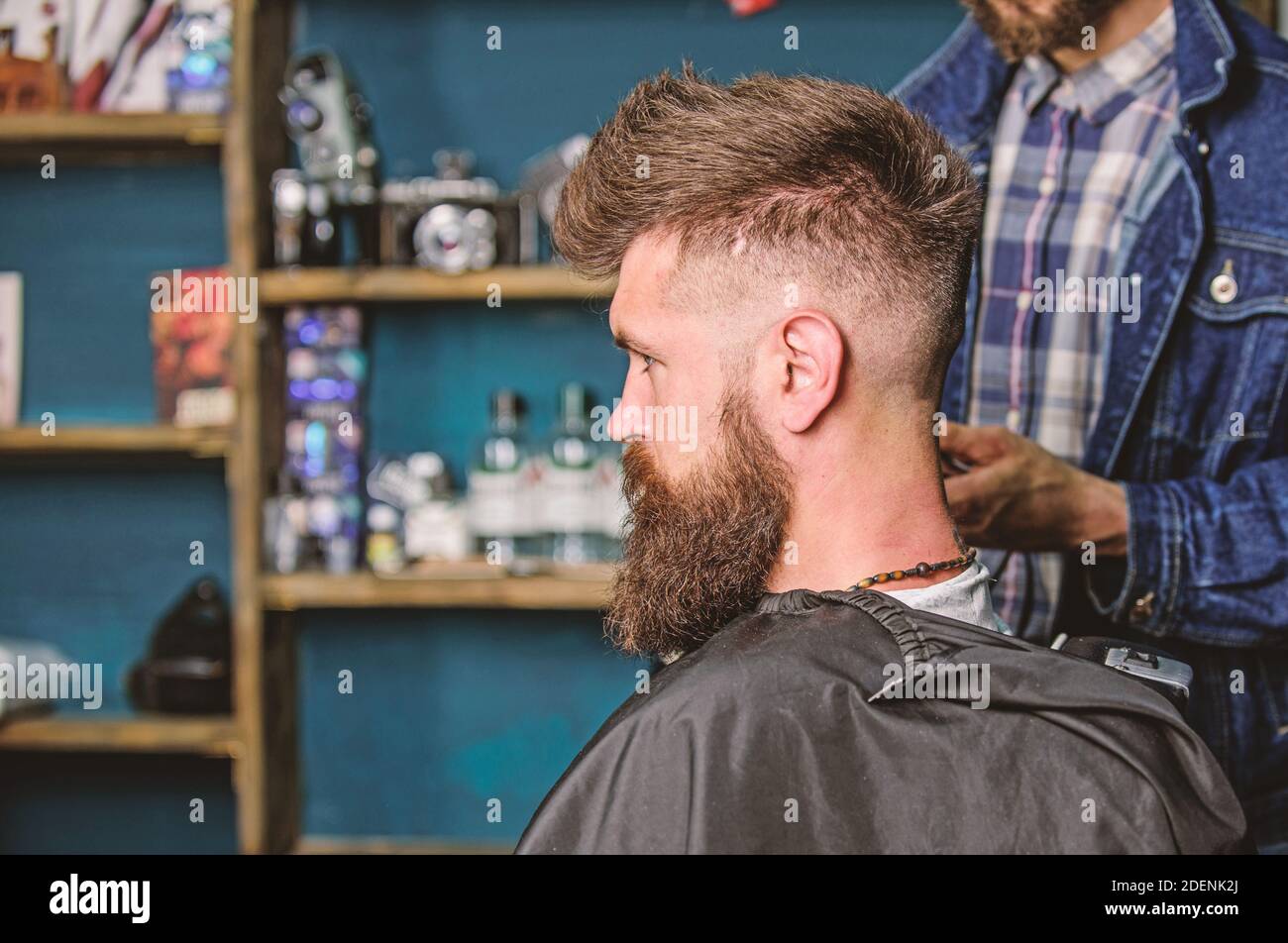 Hairstyle service concept. Hipster bearded client got hairstyle. clipper works on for bearded man, barbershop background. Barber with trimmer or clipper shaved neck of client Stock Photo - Alamy