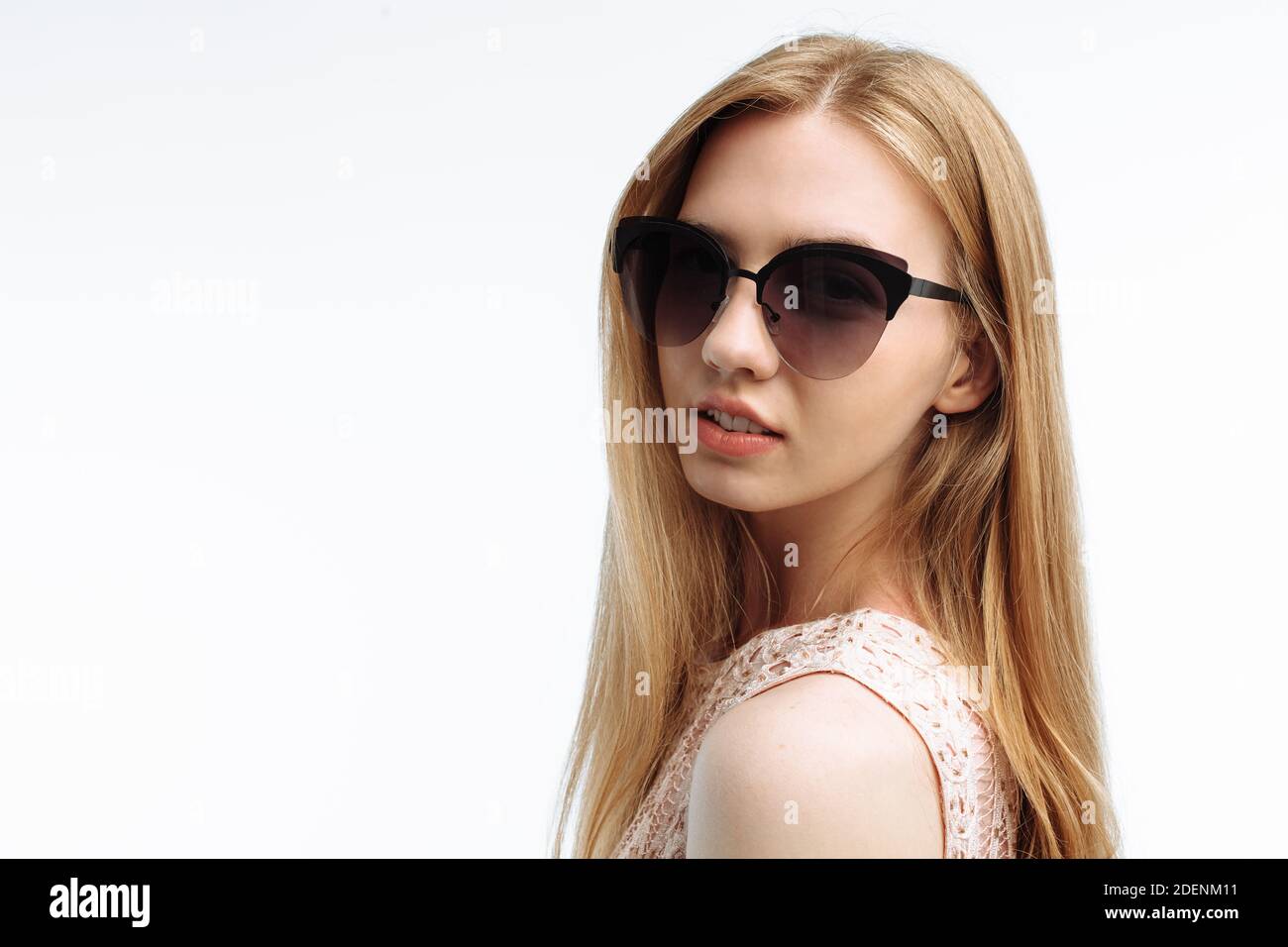 Portrait of a young stylish girl, model posing with glasses on a white ...
