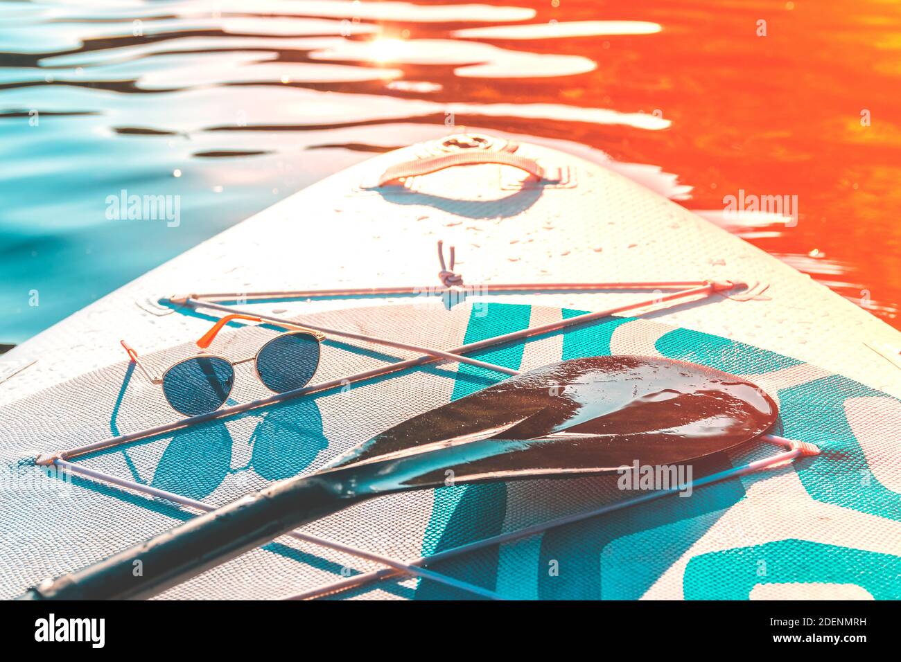 Vacation at sea. Fashion sunglasses on a paddleboard surf. Relax and travel. Hot summer day. Water sports. Stock Photo