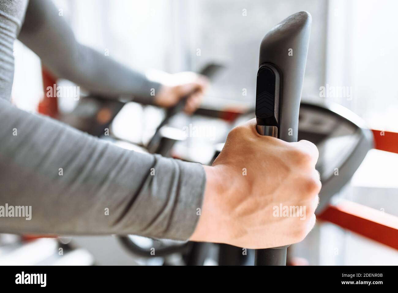 Training on a sports bike in the gym, hand close-up holding the handle of the bike, man Stock Photo