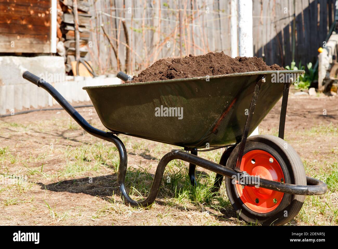 Wheelbarrow full of soil in a garden Stock Photo Alamy