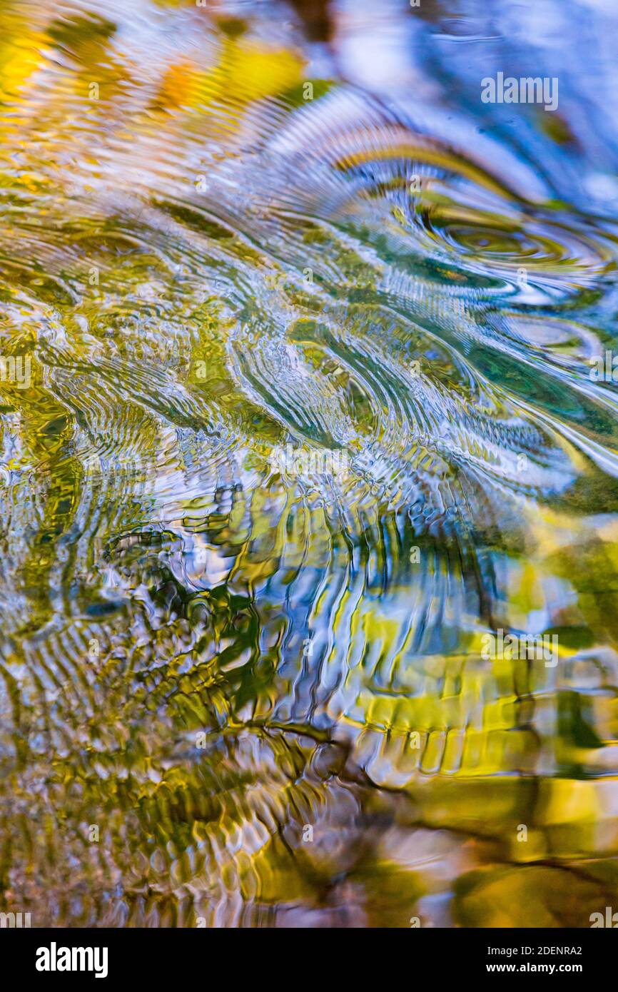 Groovy patterns and colours on the flowing water of a river in Autumn Stock Photo