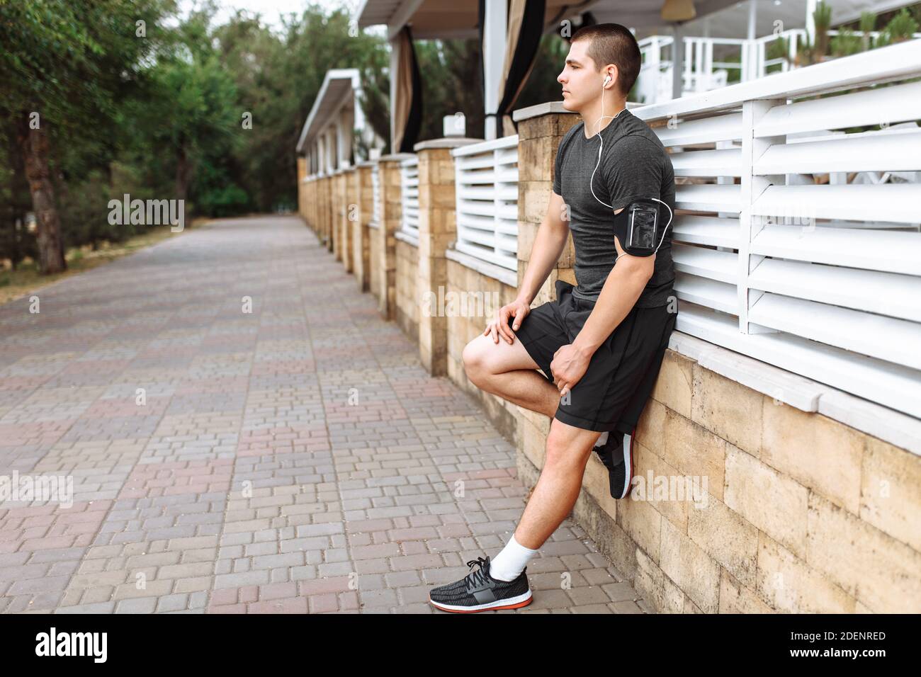 Athletic man posing on wall background, morning jog, exercise Stock