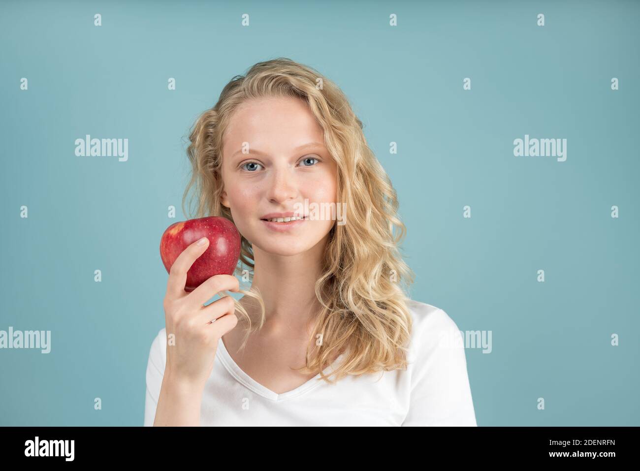 Portrait of young smiling woman with red apple. Fresh face, natural beauty Stock Photo