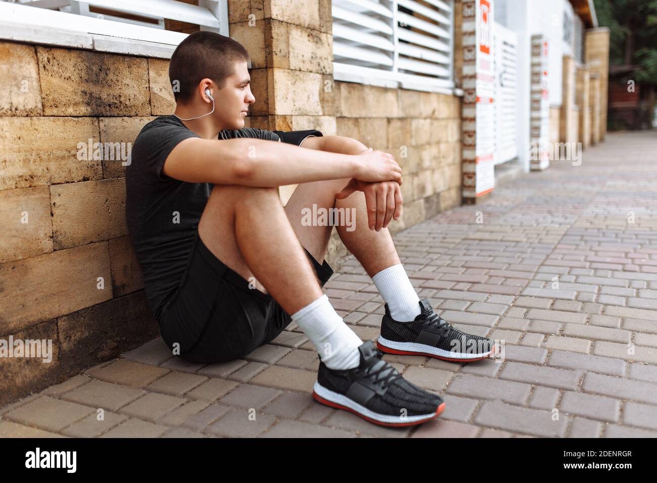 Athletic man posing on wall background, morning jog, exercise Stock