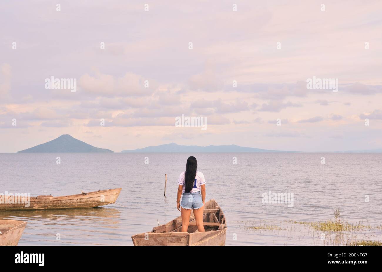 Rear view of woman looking at sky while standing on boat in the middle of lake Managua Stock Photo