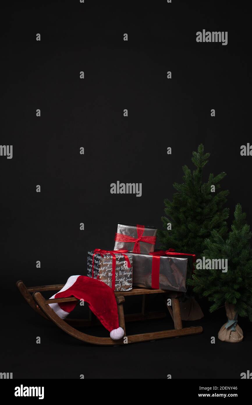 Rustic sleigh with gift boxes next to Christmas tree Stock Photo