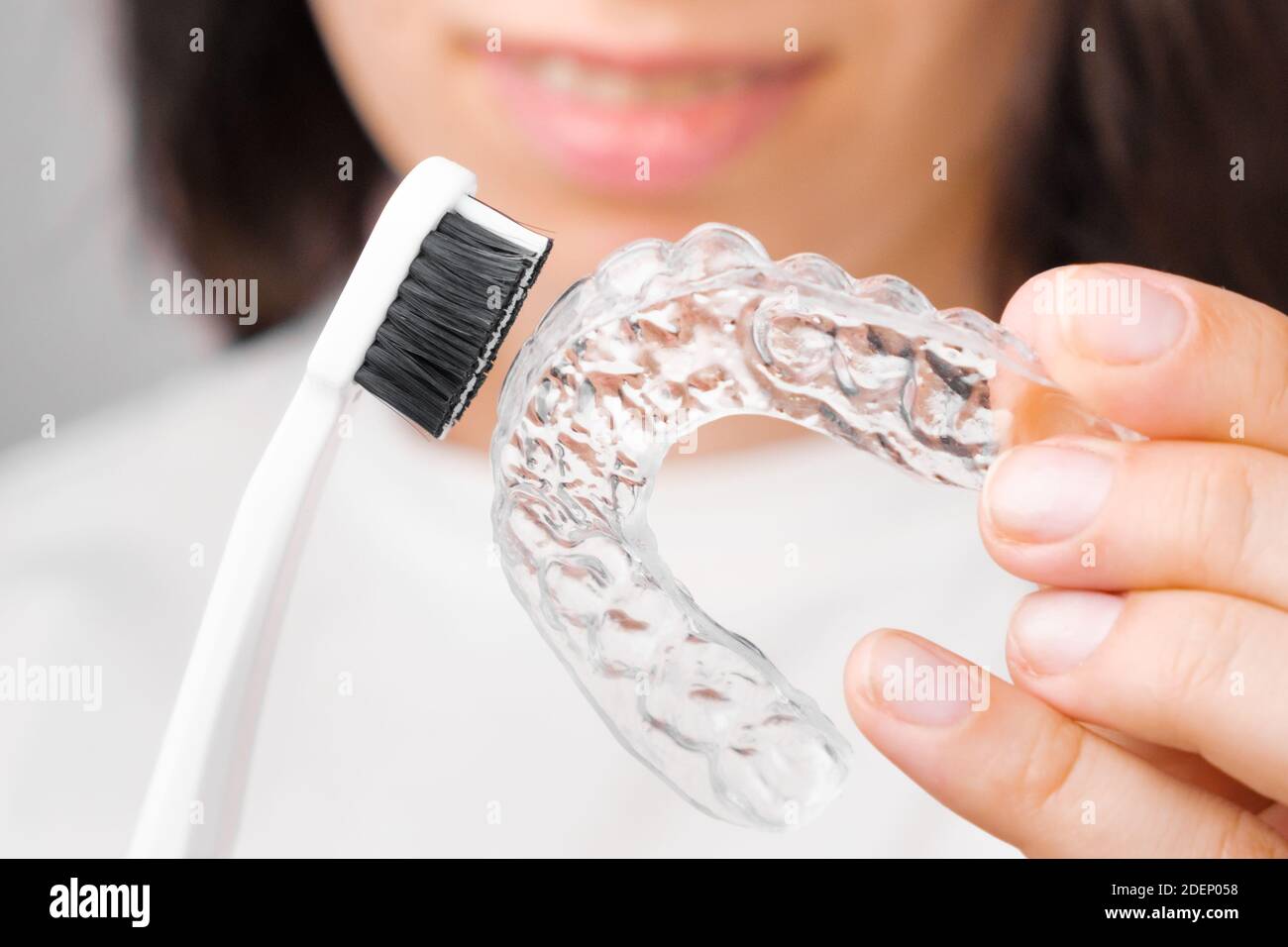 Close up woman showing how to clean invisible removable braces or