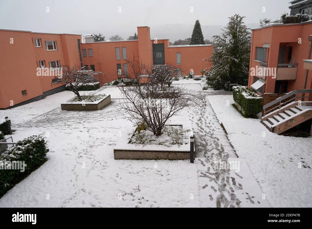 cYard in winter under snow. The snow has not been cleared away, there are shoe imprints. They imply danger of accident on the slippery ground. Stock Photo