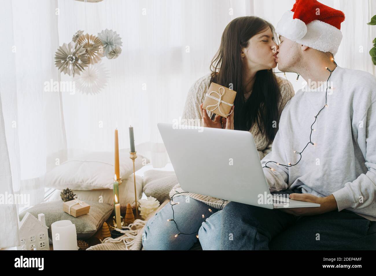 Happy young family buying christmas presents online on laptop and