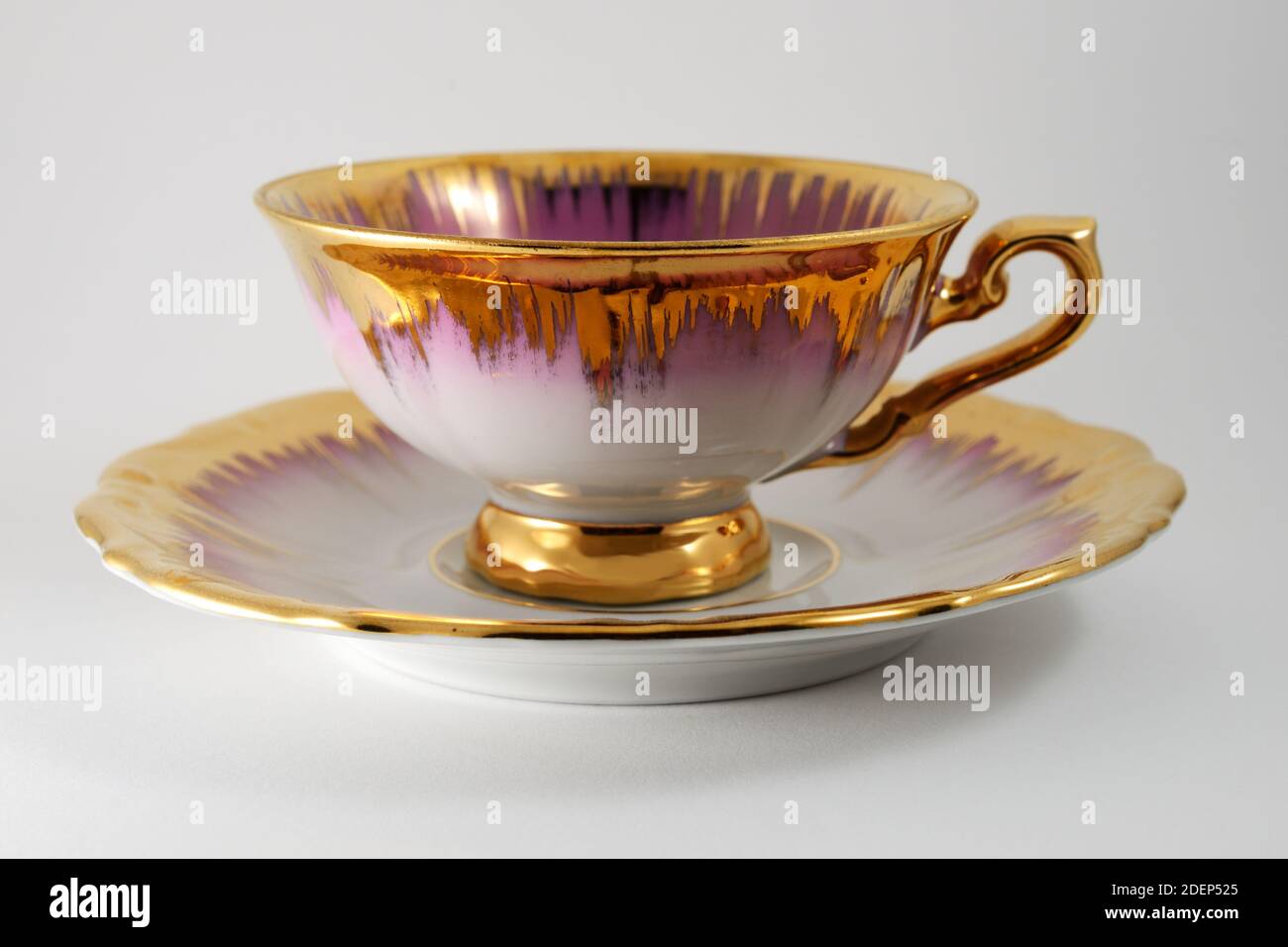empty porcelain tea cup with gilding on a white background Stock Photo