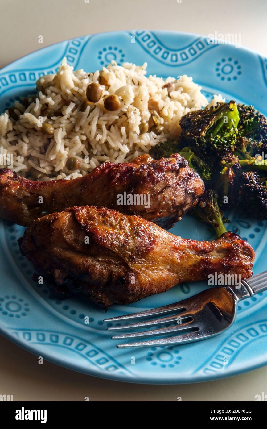 Authentic spicy Jamaican jerk chicken legs served with coconut rice and