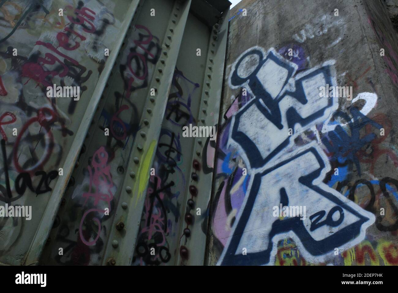 Upward shot of graffiti on a train bridge. Stock Photo
