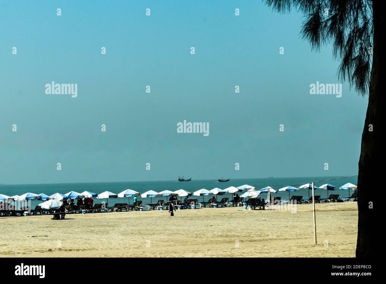 A long row of umbrellas for tourists to sit on the sea beach Stock Photo