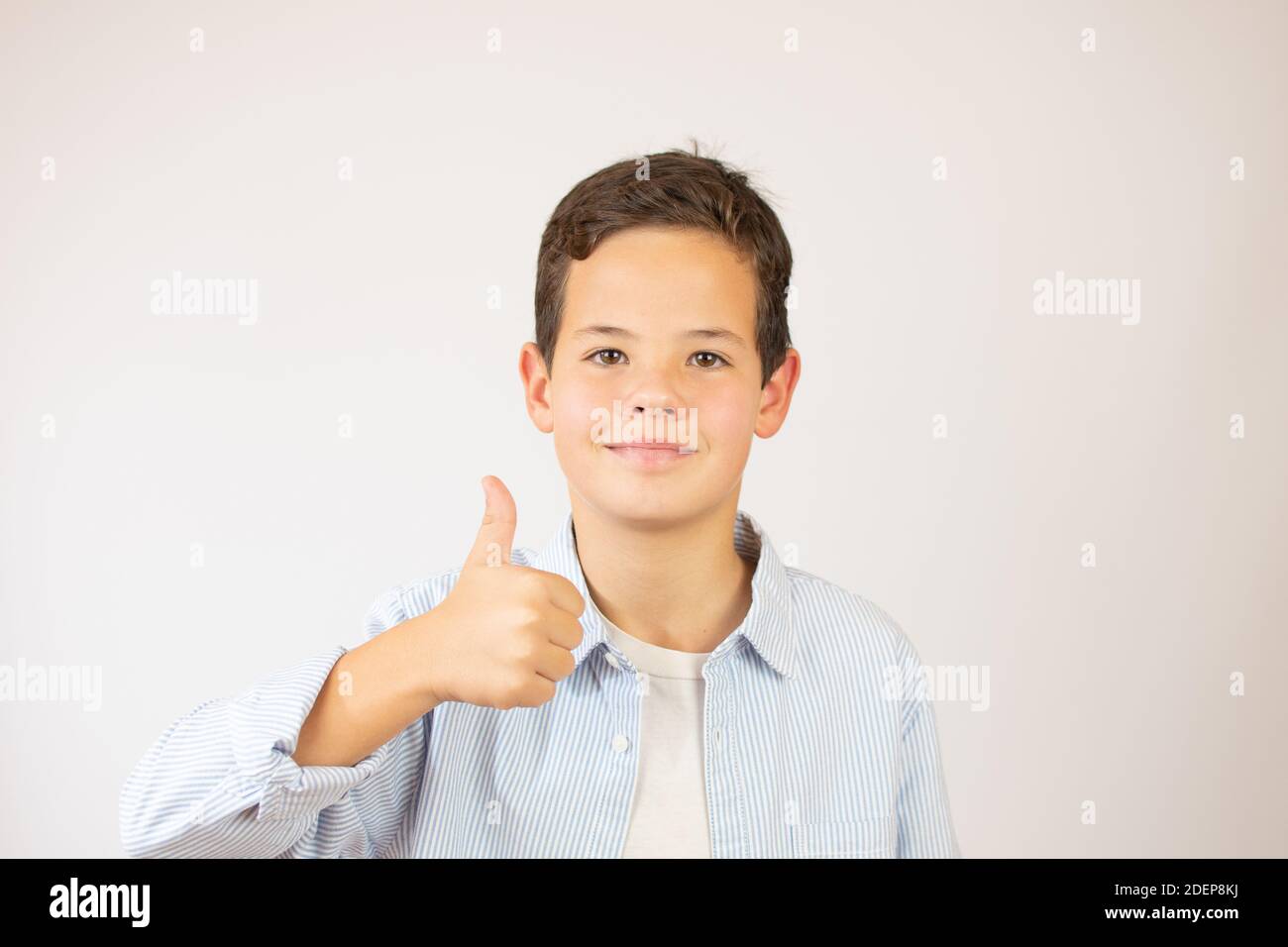 Boy showing okay gesture in sign language on white background Stock