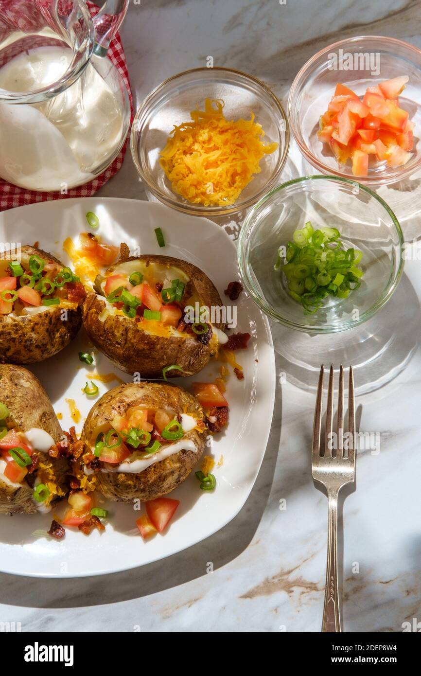 Loaded baked potato with cheddar cheese crumbled bacon bits scallions